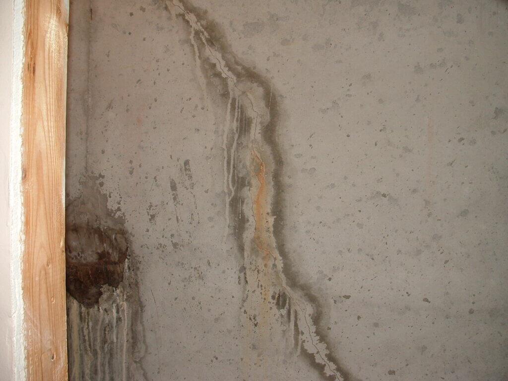 Thin hairline crack in drywall caused by water damage from a past leak.