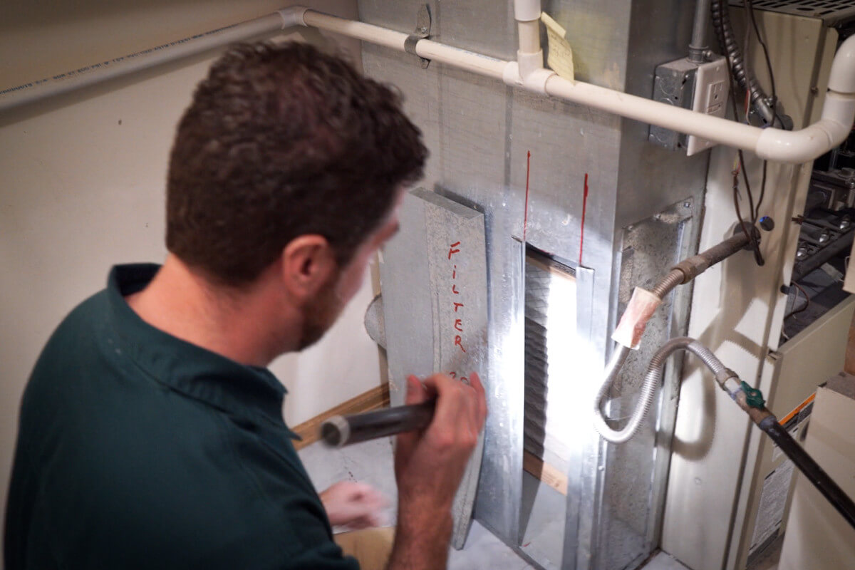 Inspector examining a furnace during a home inspection