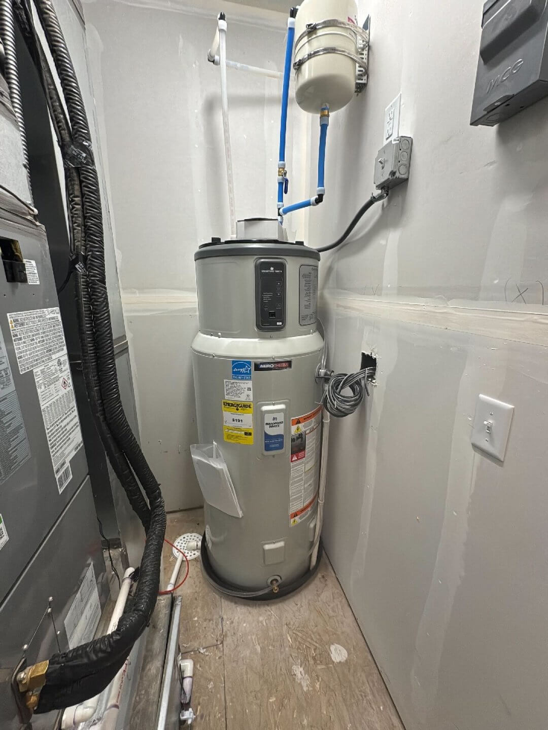 Modern heat pump water heater installed in a home utility area, showing the energy-efficient hybrid design used for water heater replacement.