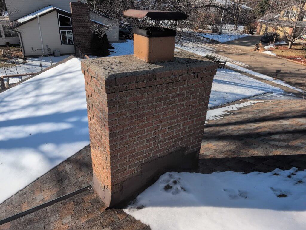 A clear view of a properly installed spark arrestor on a Denver home chimney, showing how the mesh screen helps prevent embers, debris, and animals from entering or escaping the flue.